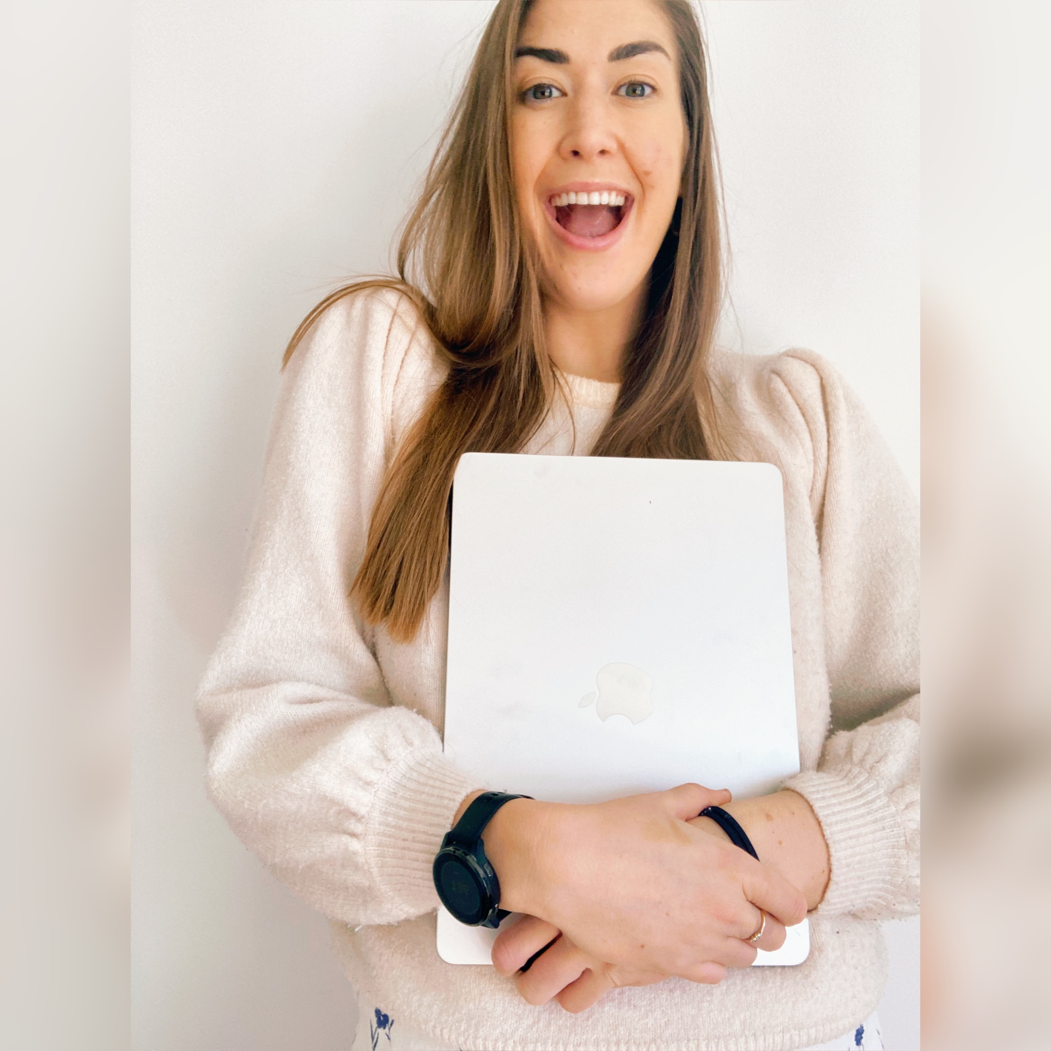 ALEC Creative, Web Designer for female entrepreneurs, smiling whilst holding silver mac book.