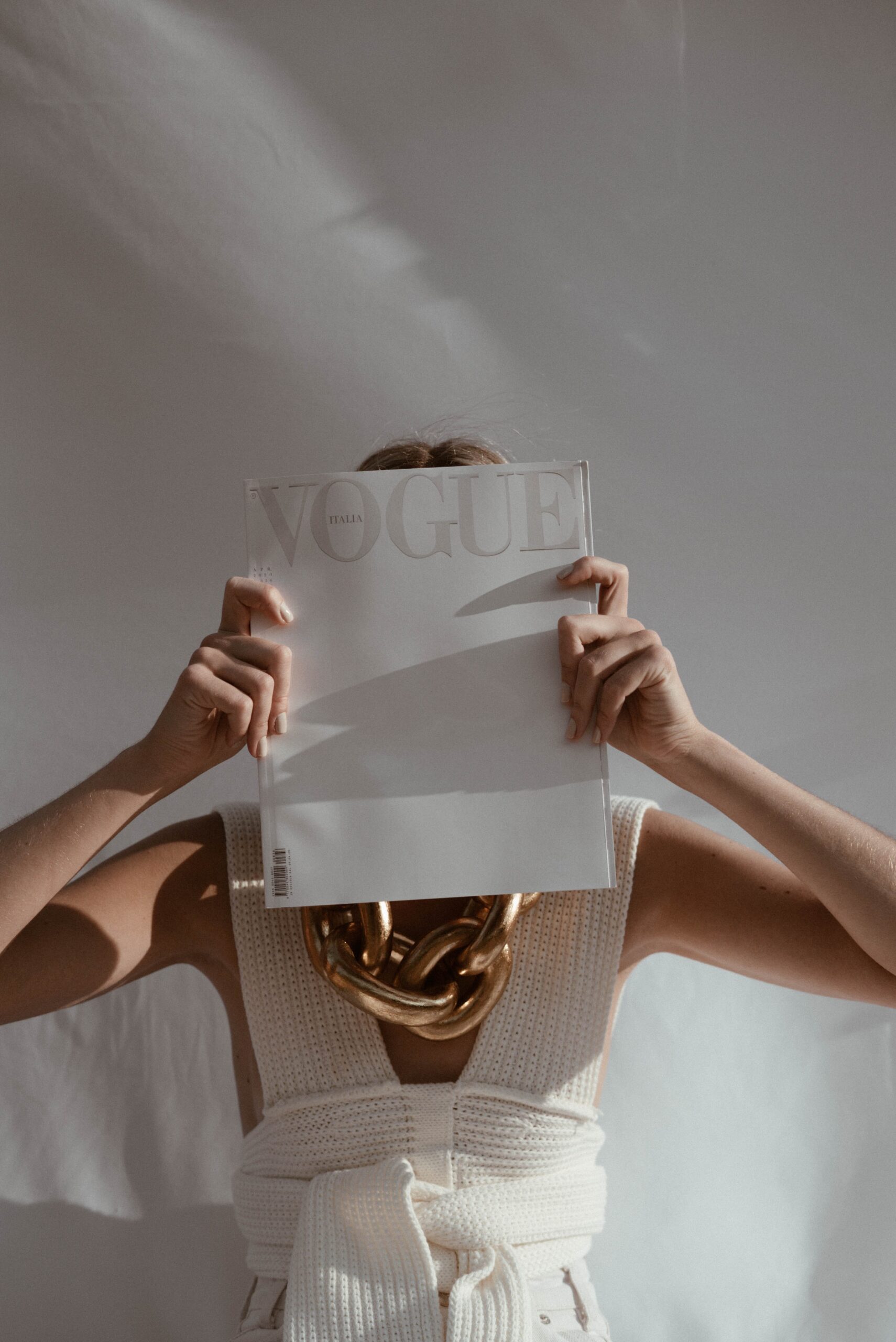 woman with luxury vogue magazine in front of her face